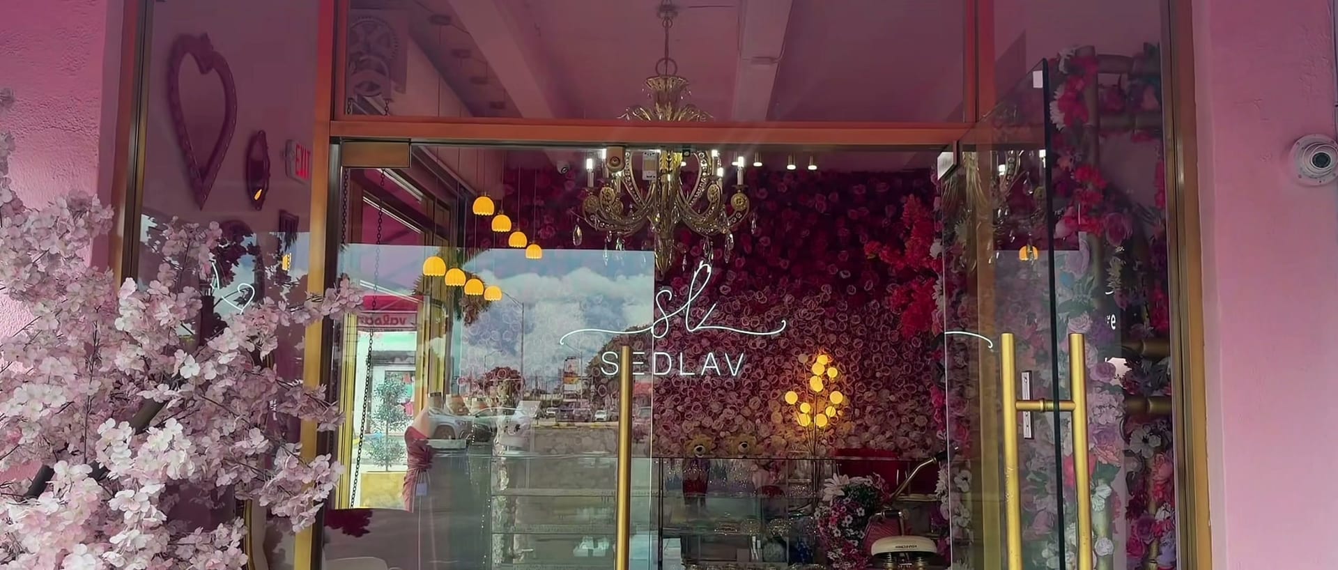 The glass entrance of the SEDLAV salon with its neon logo